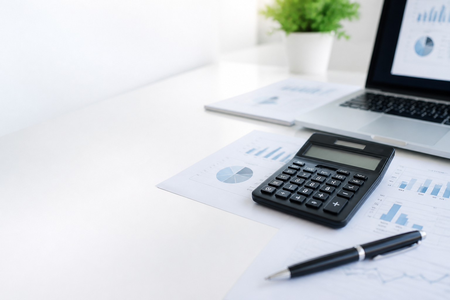 Escritorio profesional con calculadora, computador y reportes financieros